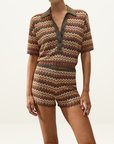 Faithfull Raya polo top in Lais stripe featuring a crochet-feel knit, collared neckline, and metallic chevron pattern.