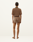 Back view of a woman wearing a Faithfull Raya polo top and matching shorts in a crochet-feel Lais stripe knit.