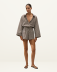 Faithfull Belas cotton playsuit in Rita stripe port with oversized long sleeves, collared neckline, and drawstring waist.