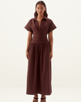 Model wearing a chocolate brown Sovere Lyra midi dress in stretch cotton with a pleated bodice and gathered full skirt.