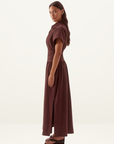Model wearing a chocolate brown Sovere Lyra midi dress in stretch cotton with a collared bodice and gathered skirt.