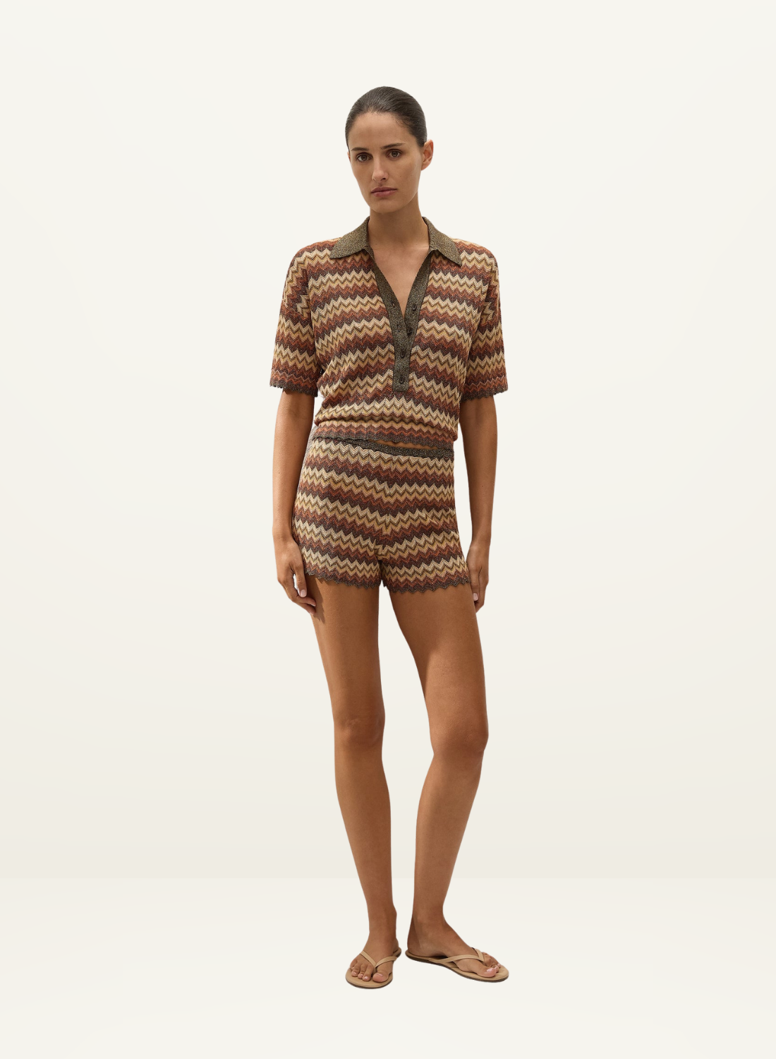Model wearing a Faithfull Raya crochet polo top and matching shorts in a multi-colored Lais stripe knit pattern.