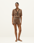 Model wearing a Faithfull Raya crochet polo top and matching shorts in a multi-colored Lais stripe knit pattern.