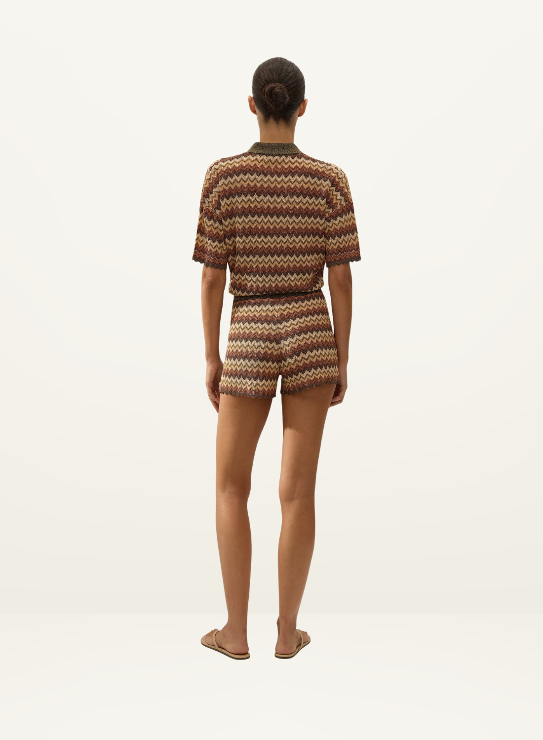 Back view of a woman wearing a Faithfull Raya polo top and matching shorts in a crochet-feel Lais stripe knit.