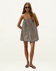 Model wearing a strapless Faithfull Camila mini dress in Rita stripe port cotton with a relaxed tent silhouette.