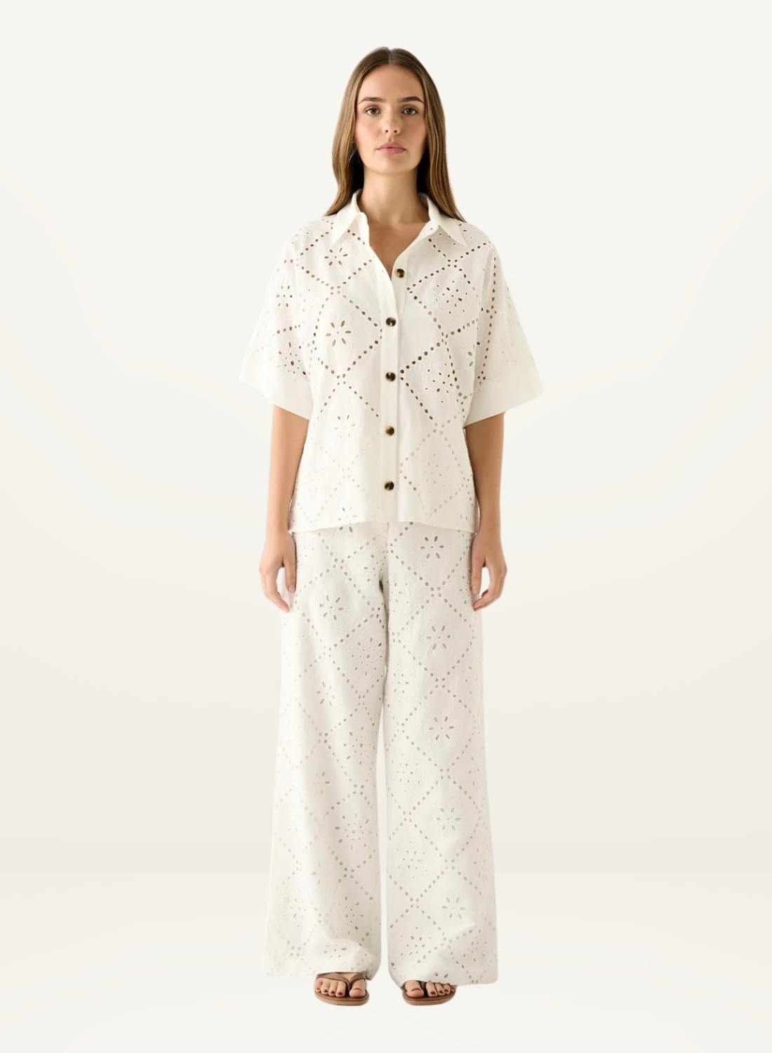 White Esmaee shirt featuring intricate eyelet embroidery, a button-down front, and a relaxed, short-sleeved silhouette.
