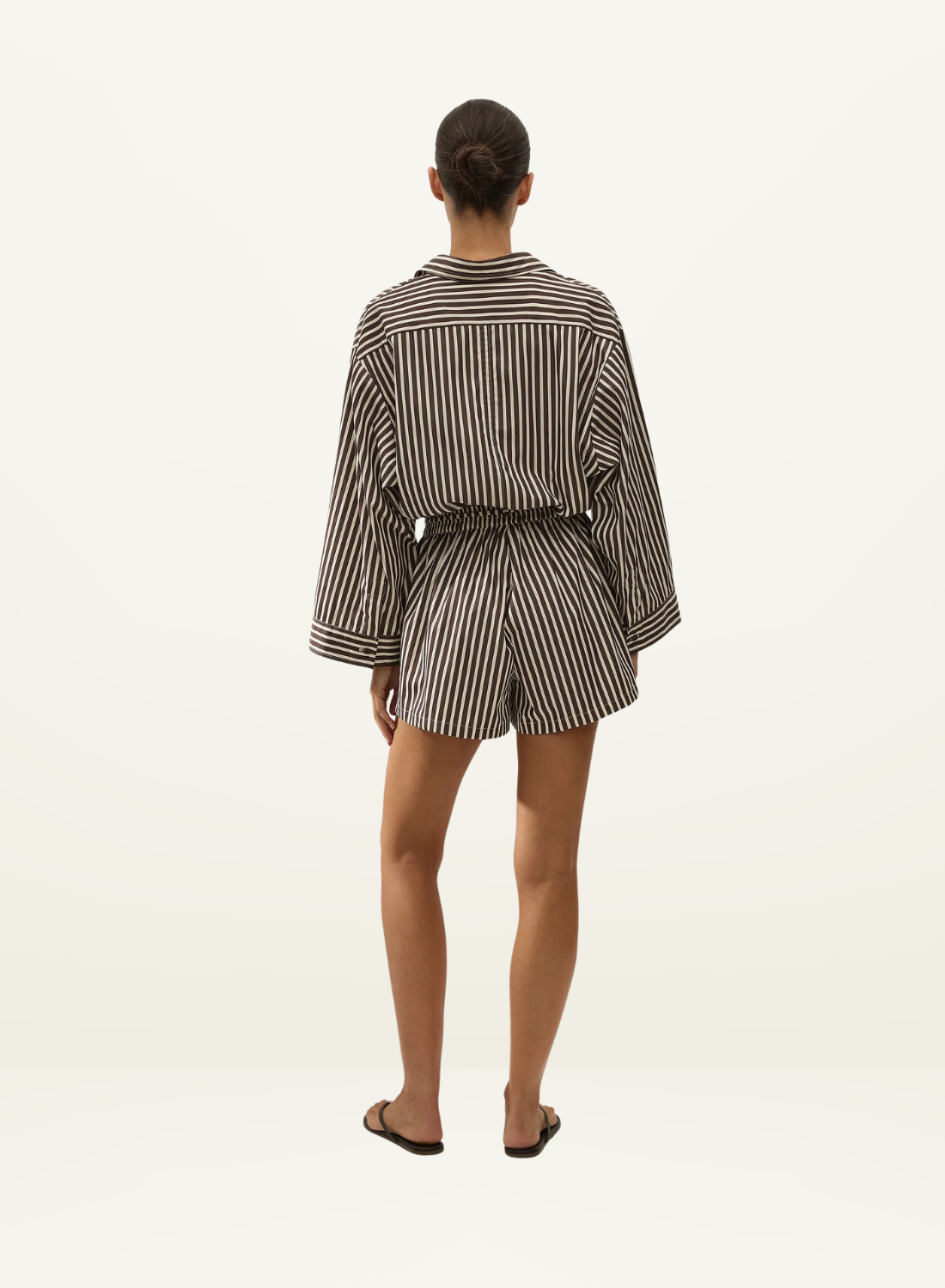 Back view of Faithfull Belas cotton playsuit in Rita stripe port featuring an oversized shirt silhouette and elastic waist.