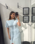 Sky blue midi dress in stretchy mesh with magyar sleeves, gathered waist detail, and a front leg split worn by a model.